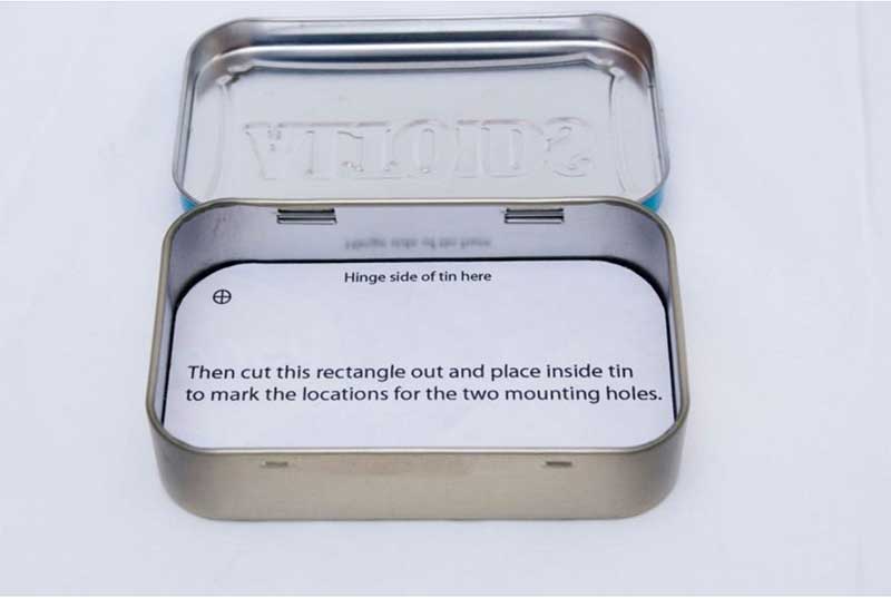 Insert the cardboard/drilling guide into the tin